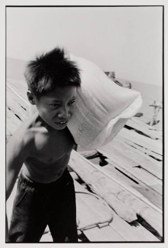 Fishing platform worker carrying rice, Indonesia