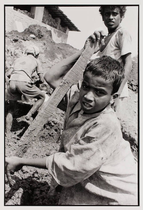 Mixing clay for bricks, India