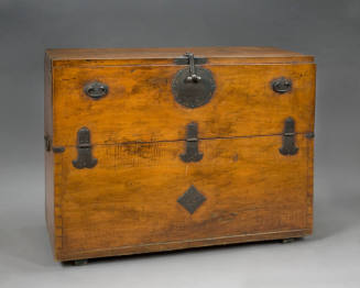 An antique wooden chest with black metal handles and latch hardware