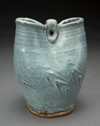 Ceramic vessel with blue speckled glaze and a pinched together center.