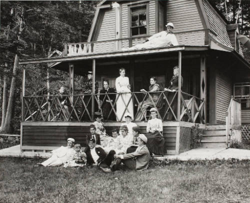 A Family group gathered on the porch of a summer cottage