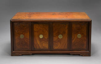 A wooden cabinet with four doors and brass knobs